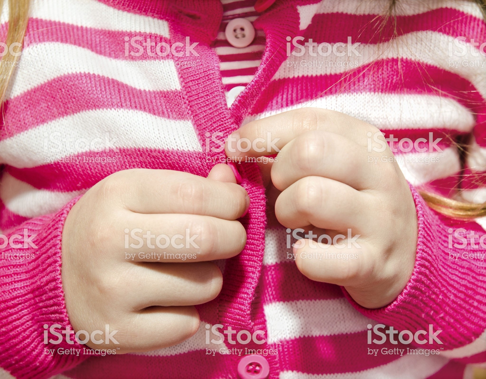 Little girl buttoning her jacket closeup Little girl buttoning her jacket closeup